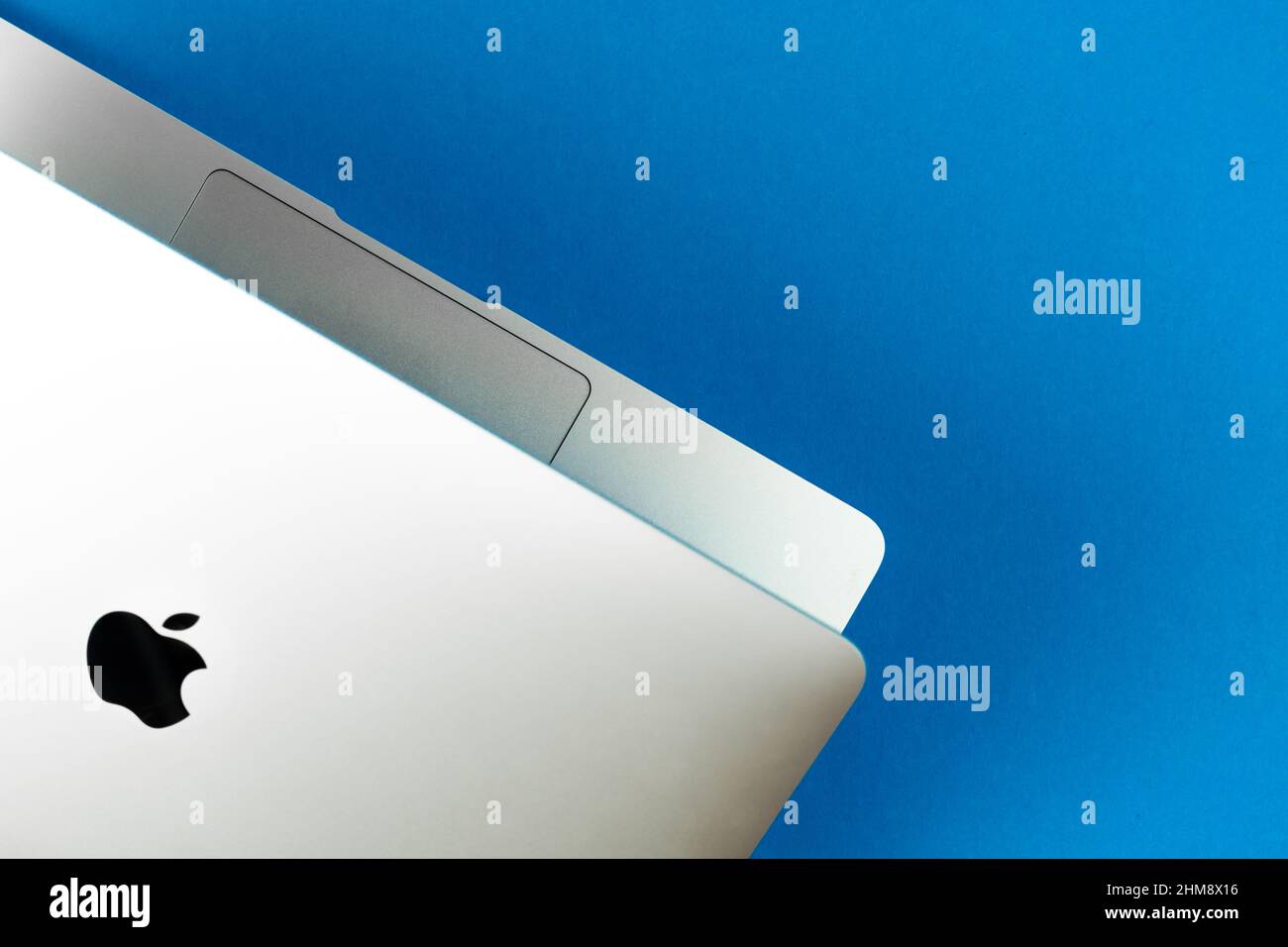 Apple Macbook Air with M1 on bright blue table background. Business and office concept, top view, flat lay Stock Photo