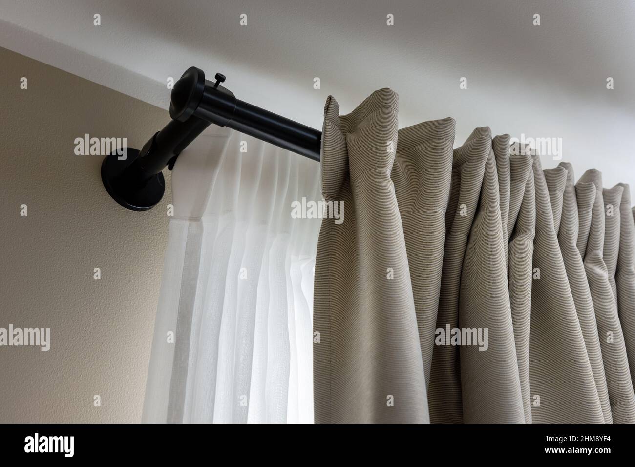 double layer curtains on black rod in living room Stock Photo