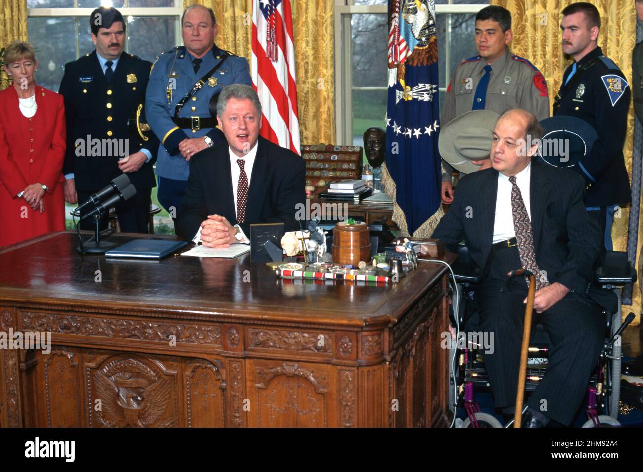 U.S. President Bill Clinton, joined by James Brady, right, Rep. Carolyn McCarthy, left, and members of law enforcement for the signing of a directive on child safety gun locks from the Oval Office of the White House, March 5, 1997 in Washington, D.C. Stock Photo