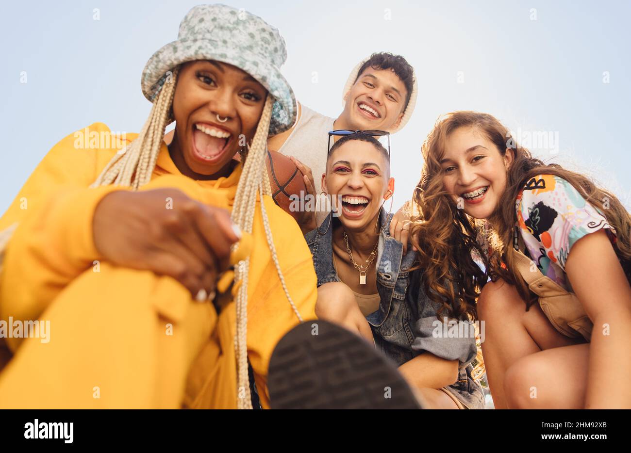 Cheerful generation z friends having fun together outdoors. Group of multiethnic friends smiling at the camera cheerfully. Vibrant young people making Stock Photo
