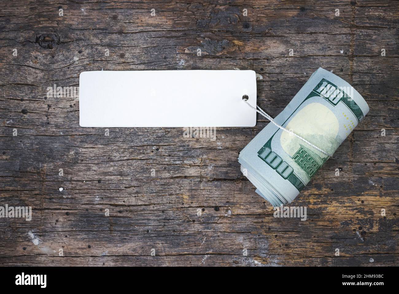 The pack of 100 dollars bills is twisted into a roll with price tag, Economy, savings and the US dollar Stock Photo