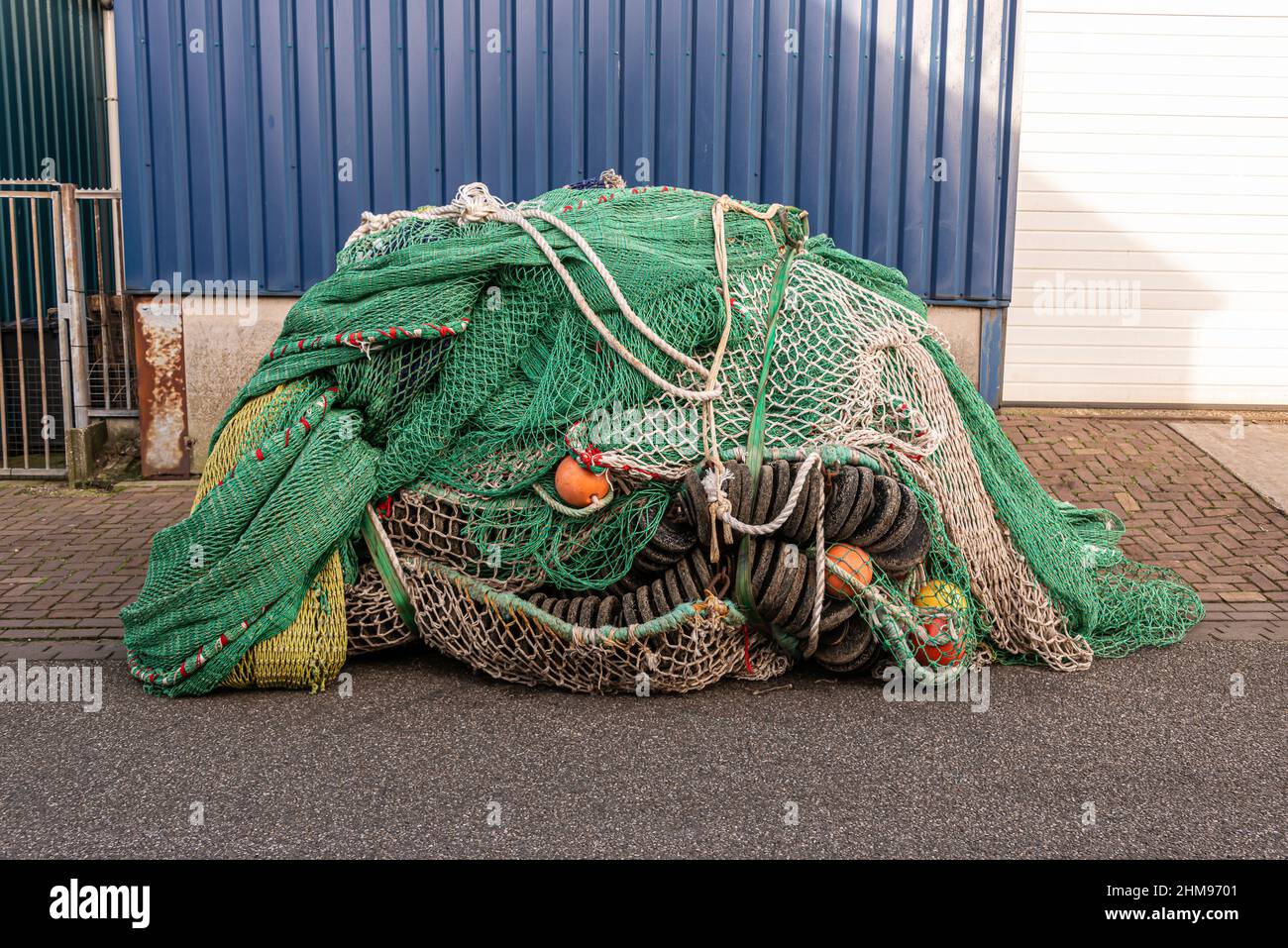 fishing nets and balls tendons and fenders used in the fish industry lie in a large heap in the street Stock Photo