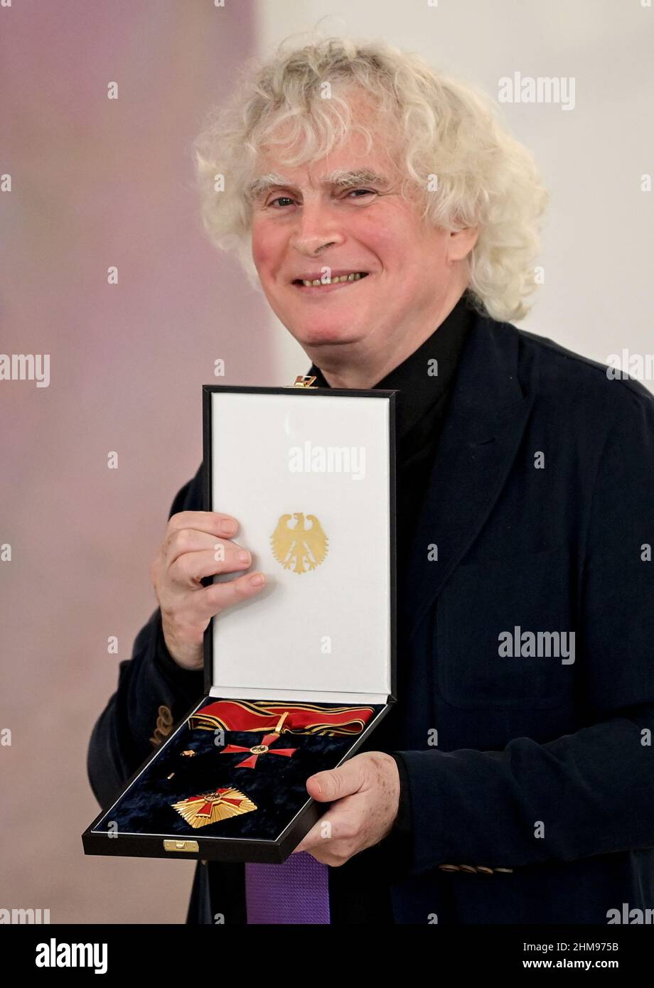 Live Order Of Merit Berlin, Germany. 08th Feb, 2022. Sir Simon Rattle, conductor shows his award at the presentation of the Grand Cross of Merit with Star of the Order of Merit of the Federal Republic