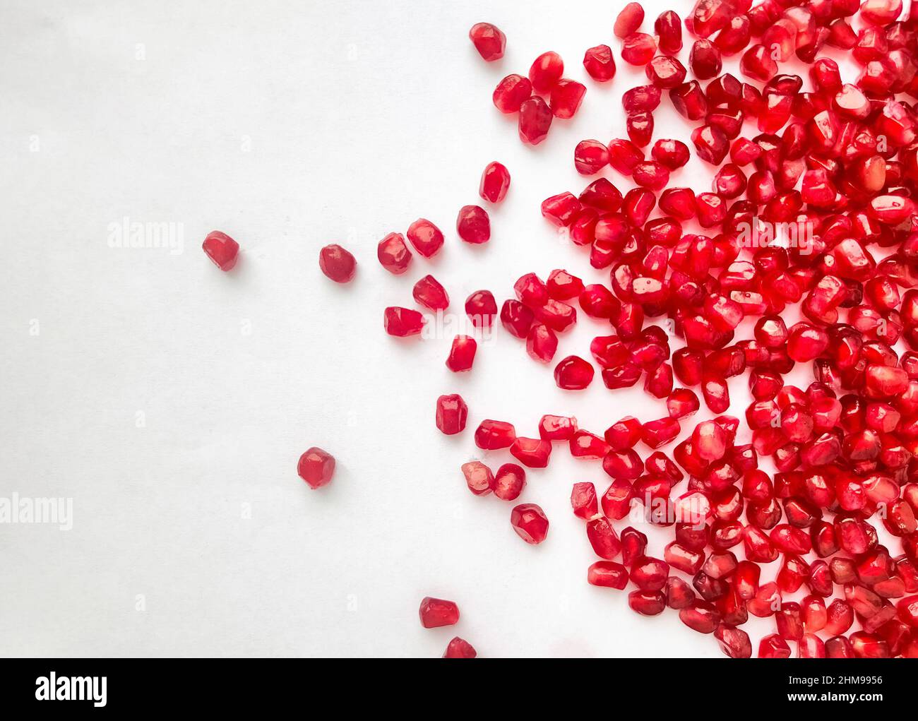 Fresh pomegranate seeds scattered on white background. Healthy food.  Stock Photo