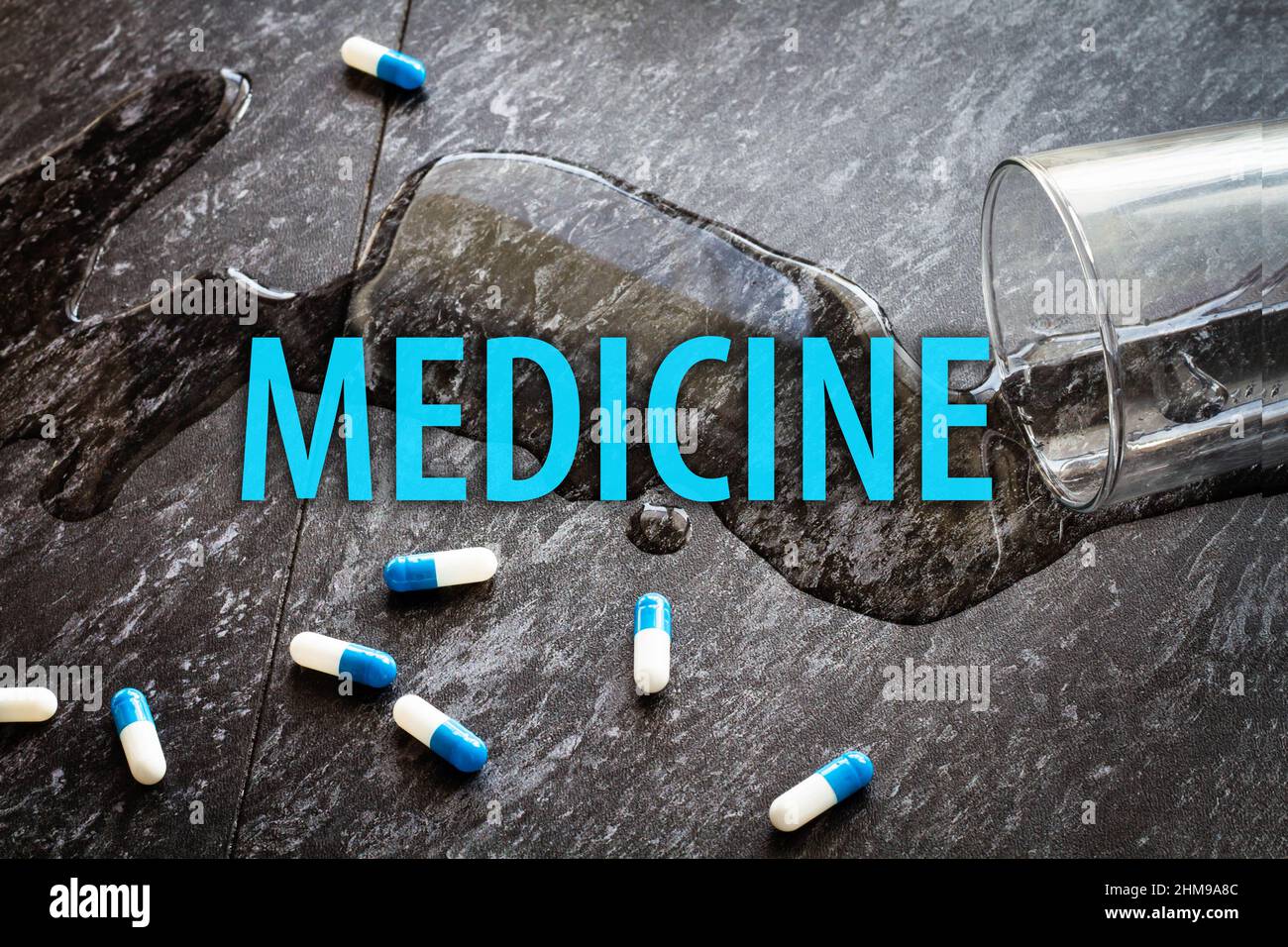 The inscription medicine on the background of pills and a glass of water. Stock Photo