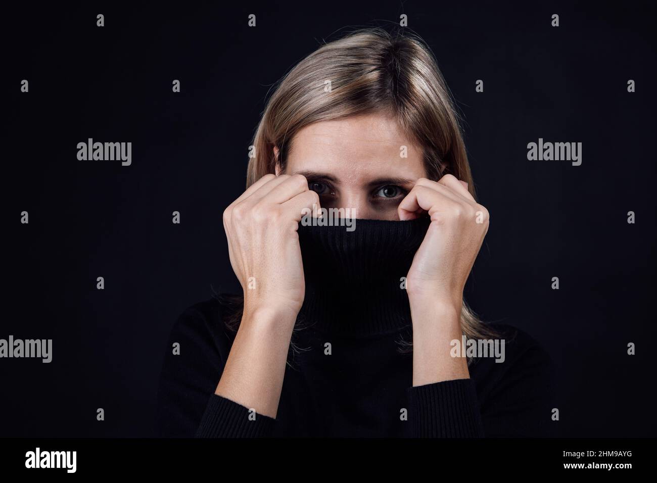 Tight cropped face of a scared young girl with hands covering