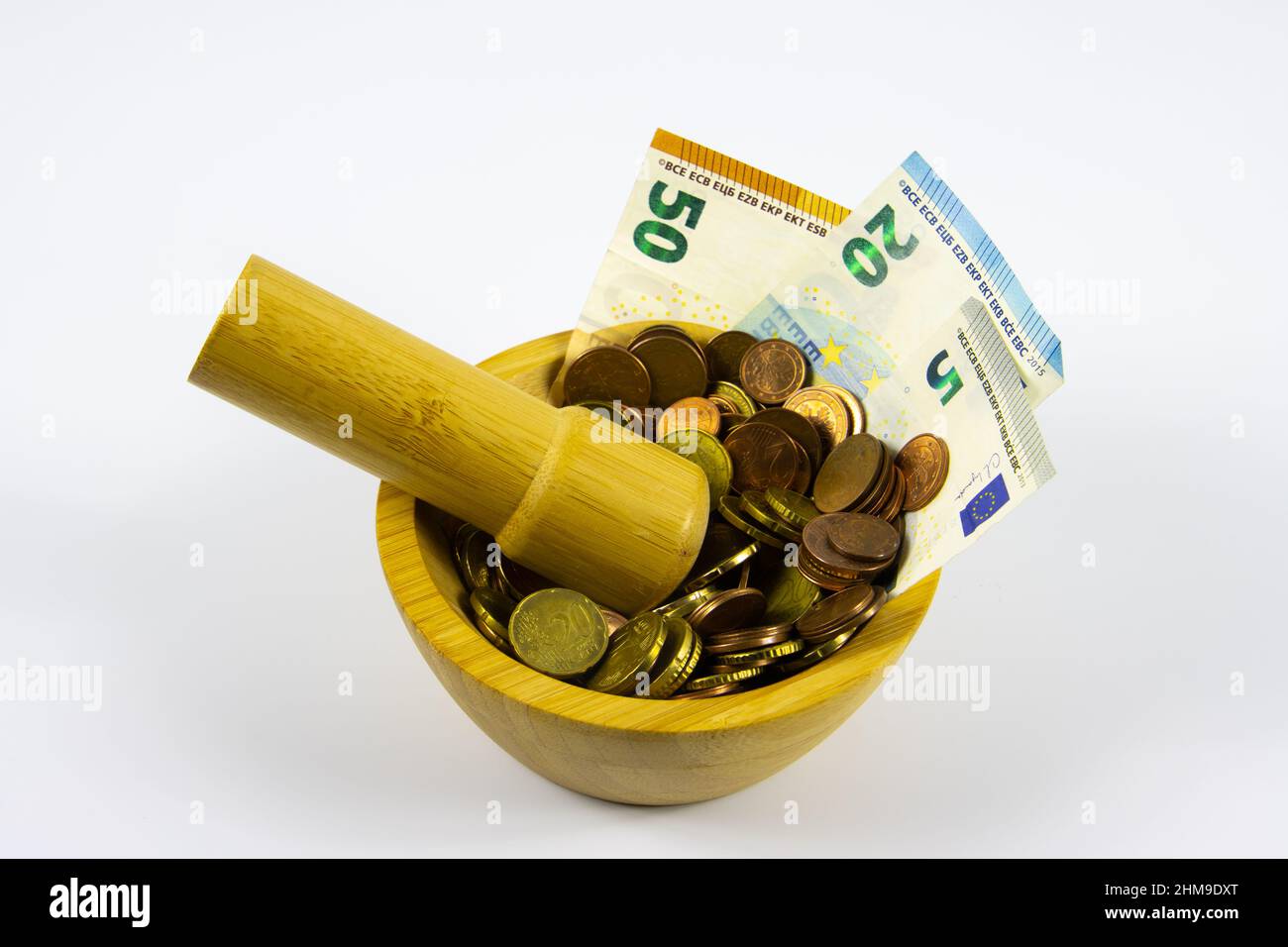 Financial Concept of Inflation - Euro Bills crushed to coins in a mortar grinded by a pestle Stock Photo