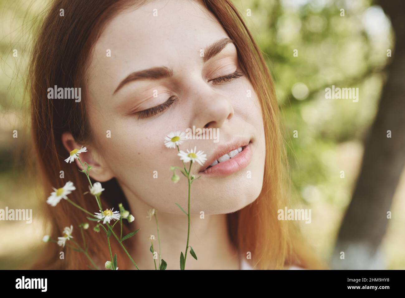 portrait of a beautiful woman with wildflowers and with closed eyes on ...