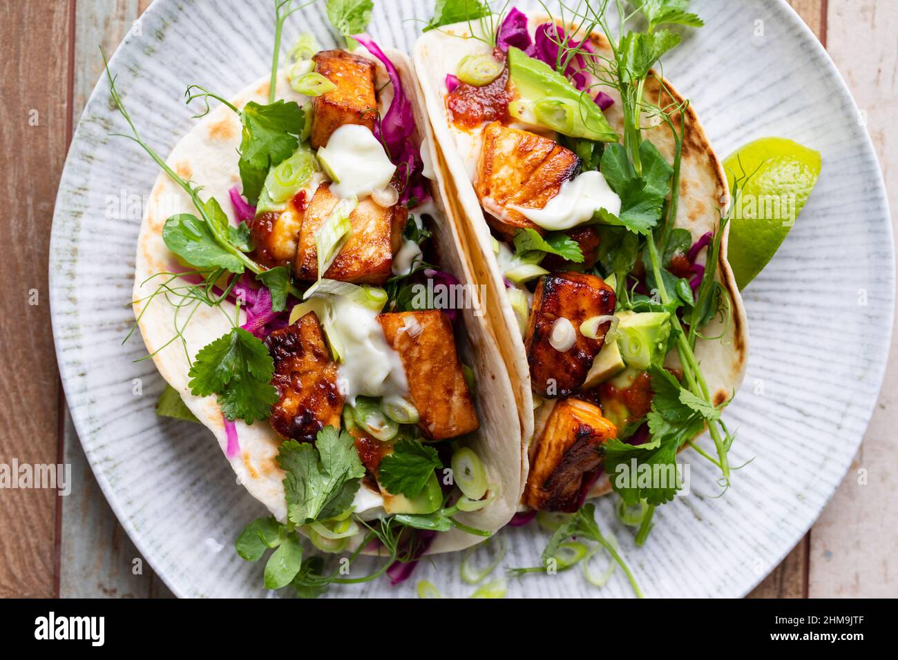 Tacos with salmon, pickled red cabbage, wasabi mayo and pea shoots Stock Photo