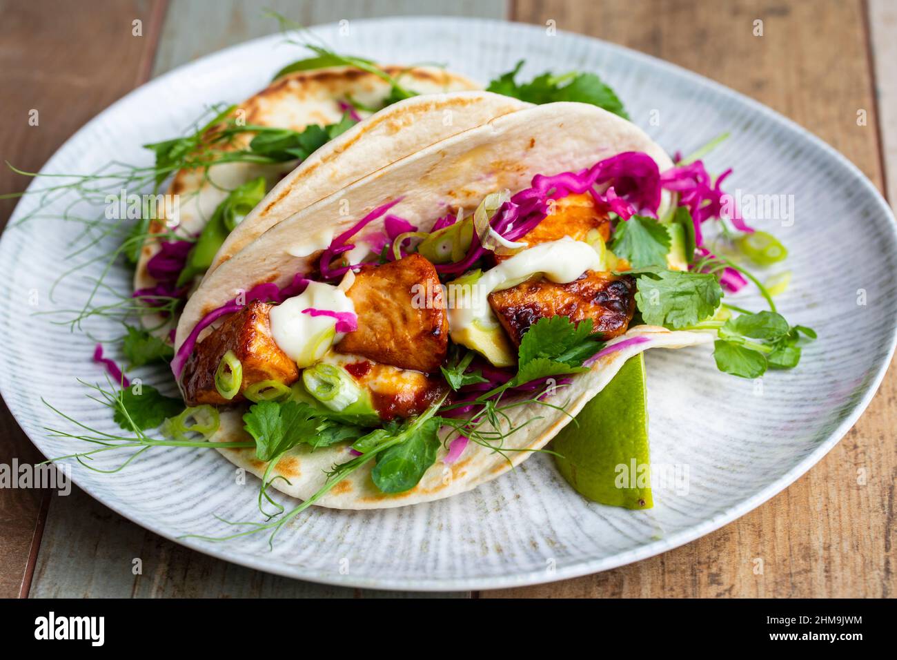 Tacos with salmon, pickled red cabbage, wasabi mayo and pea shoots Stock Photo