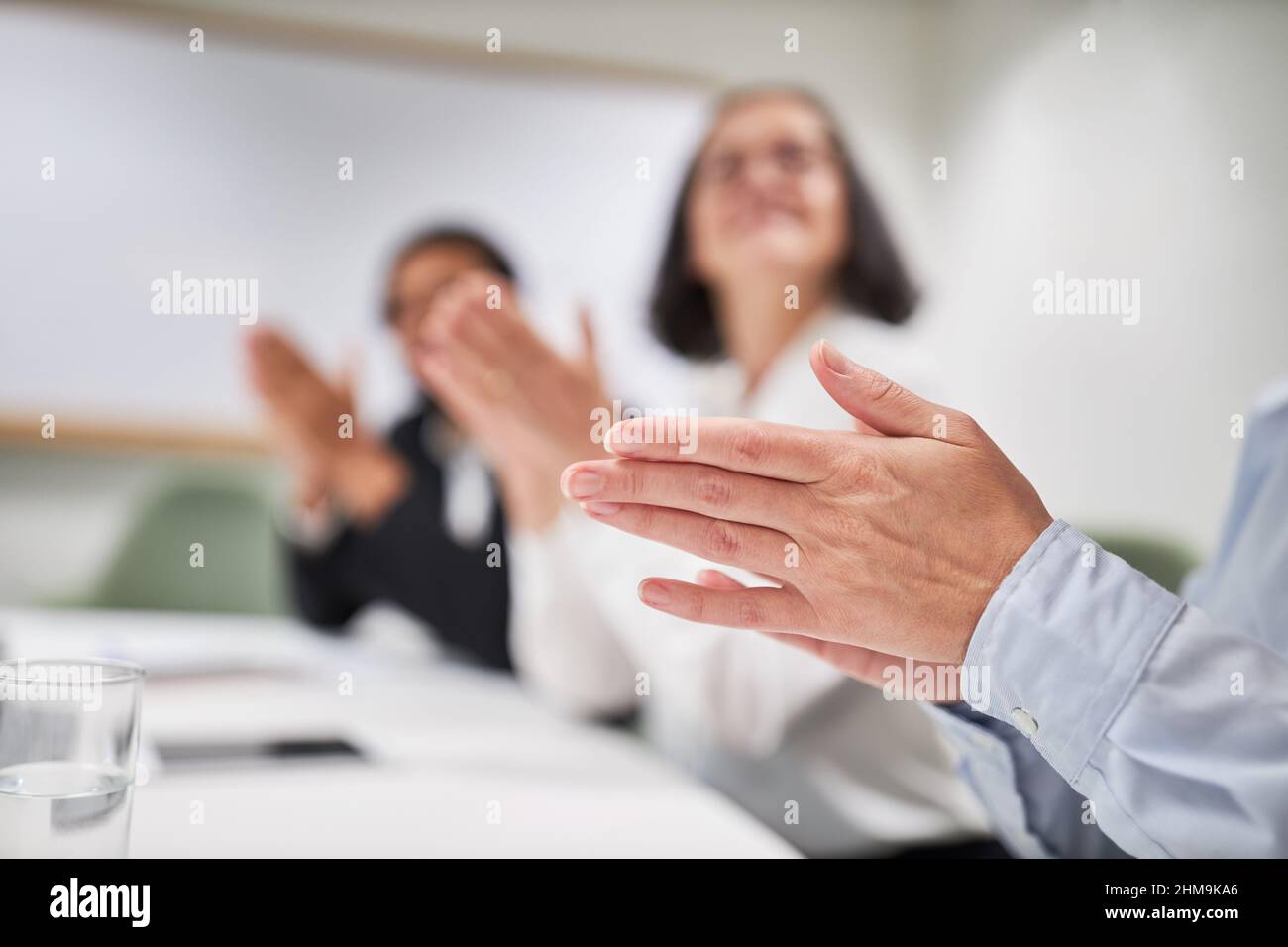 Seminar attendees give applause with their hands and clap as approval Stock Photo