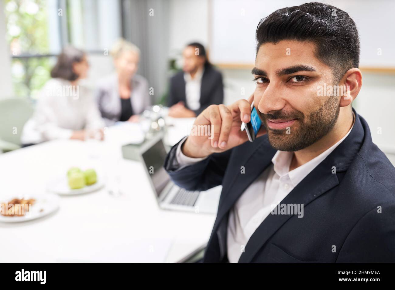 Confident businessman talking on cellphone or smartphone in conference room Stock Photo