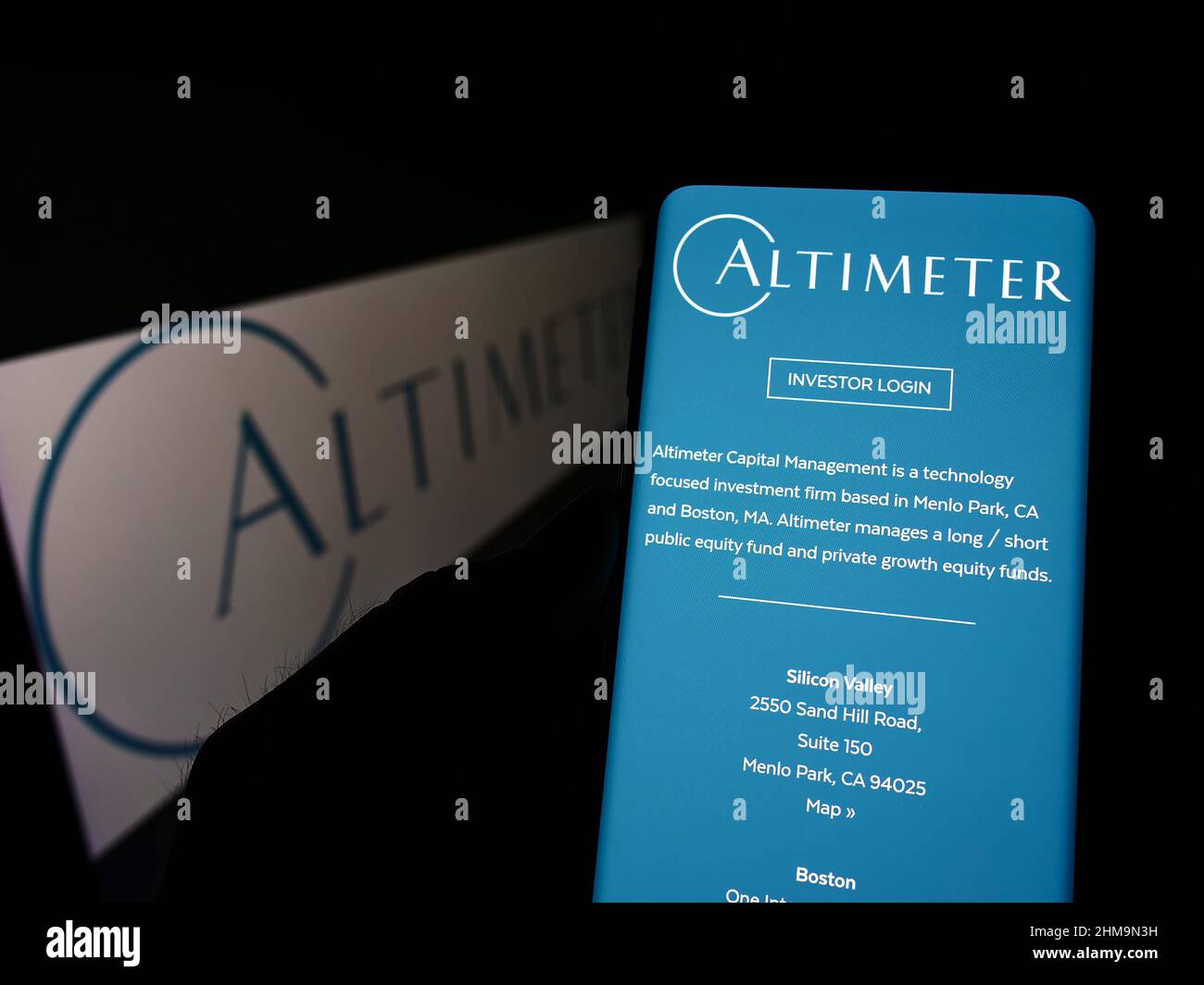 Person holding cellphone with webpage of US company Altimeter Capital