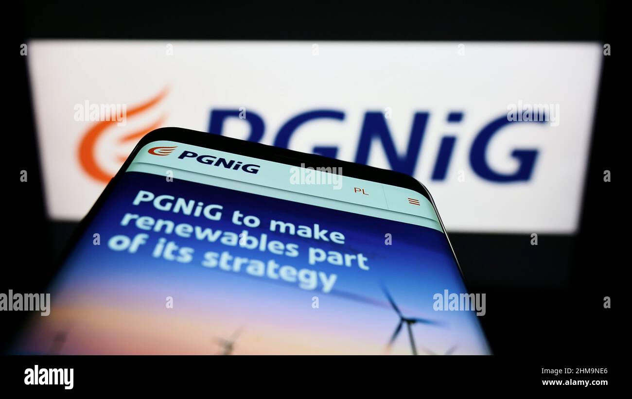 Smartphone with website of Polskie Gornictwo Naftowe i Gazownictwo S.A. (PGNiG) on screen in front of logo. Focus on top-left of phone display. Stock Photo