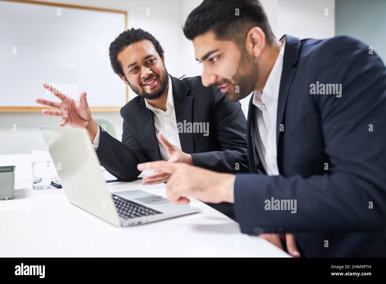 Two young business people work together as creative software developers on the laptop PC Stock Photo