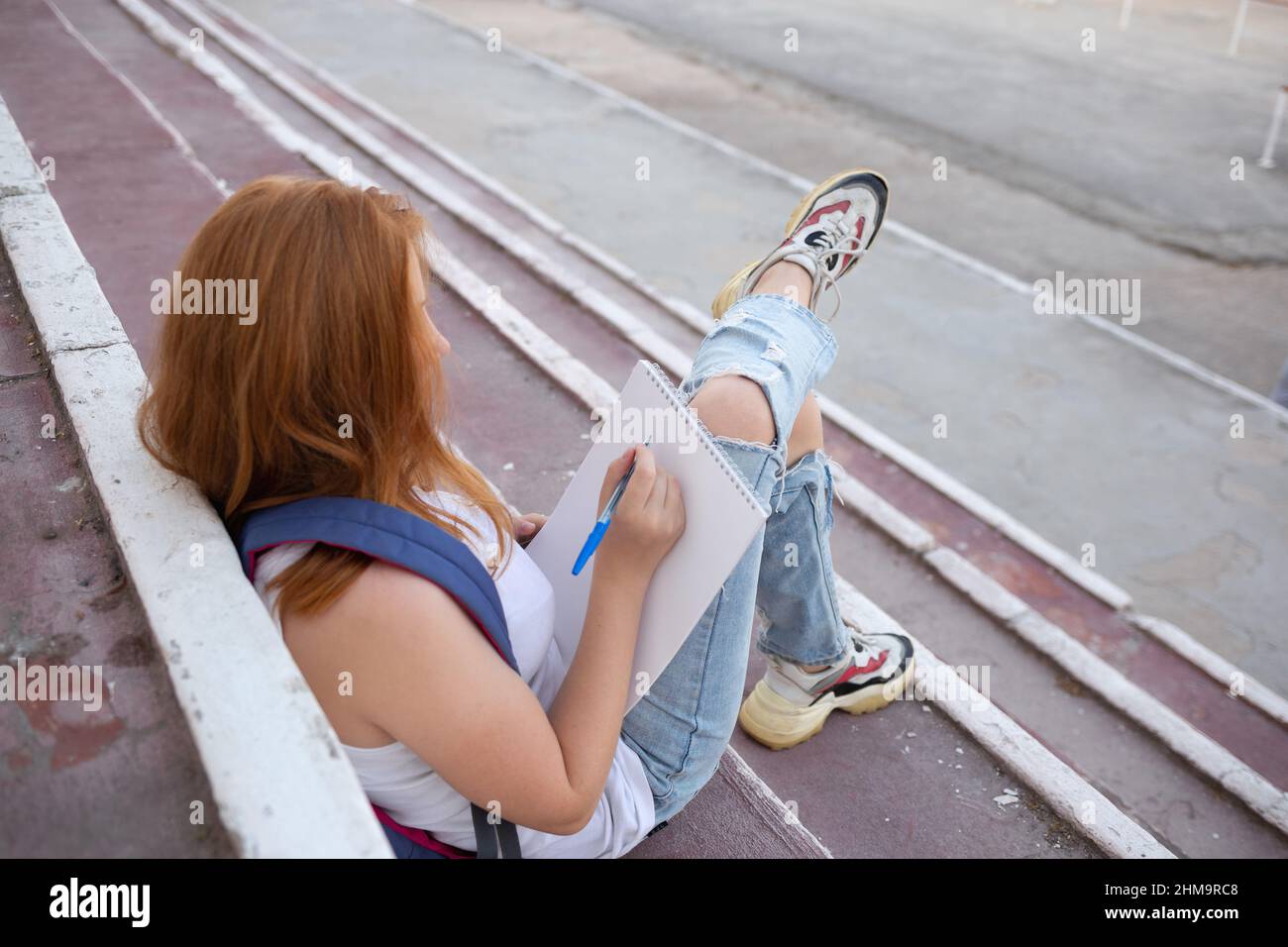 https://c8.alamy.com/comp/2HM9RC8/teenage-girl-draws-in-the-sketchbook-while-sitting-on-the-steps-2HM9RC8.jpg