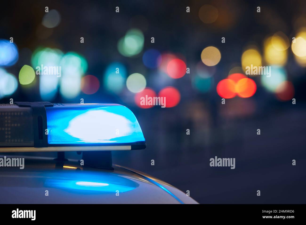 Blue flasher light of siren of police car at night city street. Themes crime, emergency and help. Stock Photo