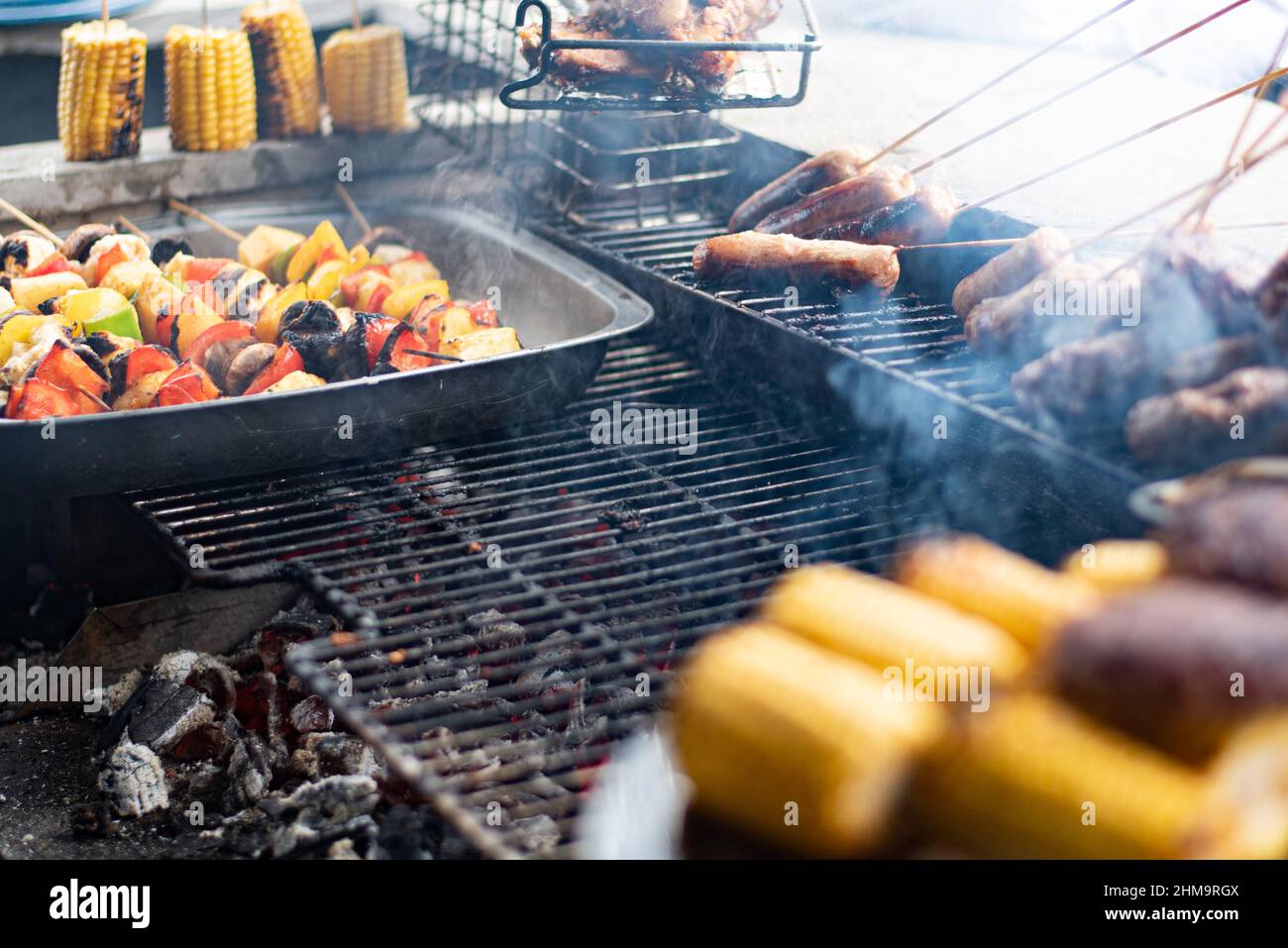 Cook grilling meat, corns and vegetables Stock Photo - Alamy