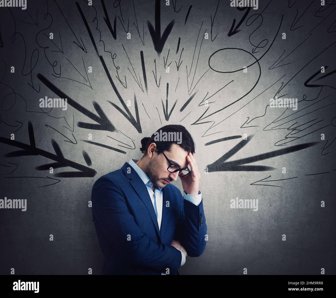 Overwhelmed businessman under pressure suffers headache and anxiety. High tension, dismay concept. Fatigue business person and multiple arrows points Stock Photo