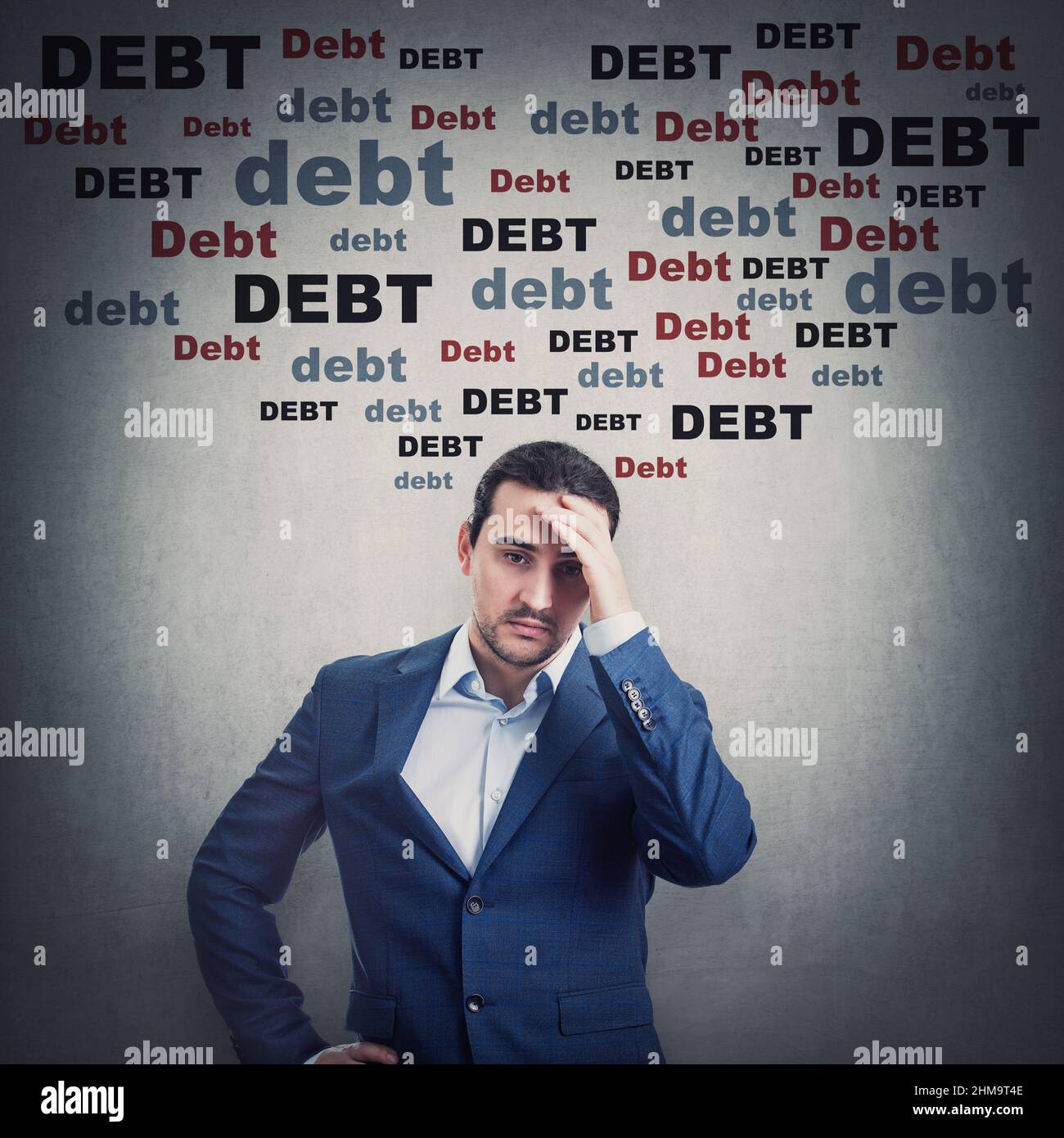 Pensive and depressed businessman keeps hand to head looking stressed and bewildered due huge debt amount. Person has financial problems, suffering he Stock Photo