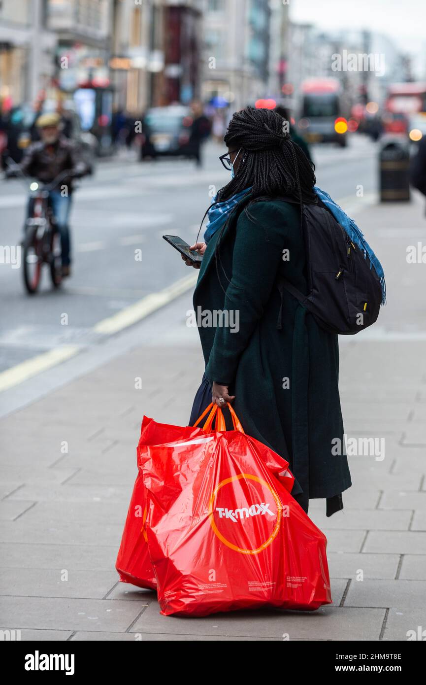 London, UK.  8 February 2022.  A shopper with her TK Maxx purchases in Oxford Street.  The British Retail Consortium has reported that, although January’s total retail sales have increased compared to January 2021, rising inflation and higher energy costs will inevitably cause shoppers to curtail their spending in the next few months resulting in a negative impact on the retail industry.  Credit: Stephen Chung / Alamy Live News Stock Photo