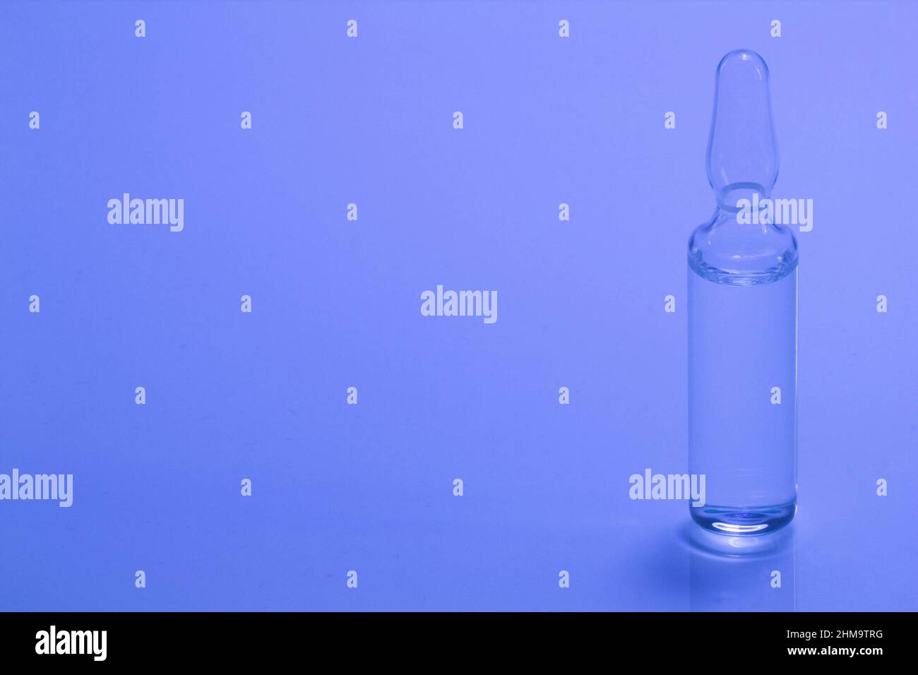 Medical ampoule on a blue background. Glass ampoule for injection with