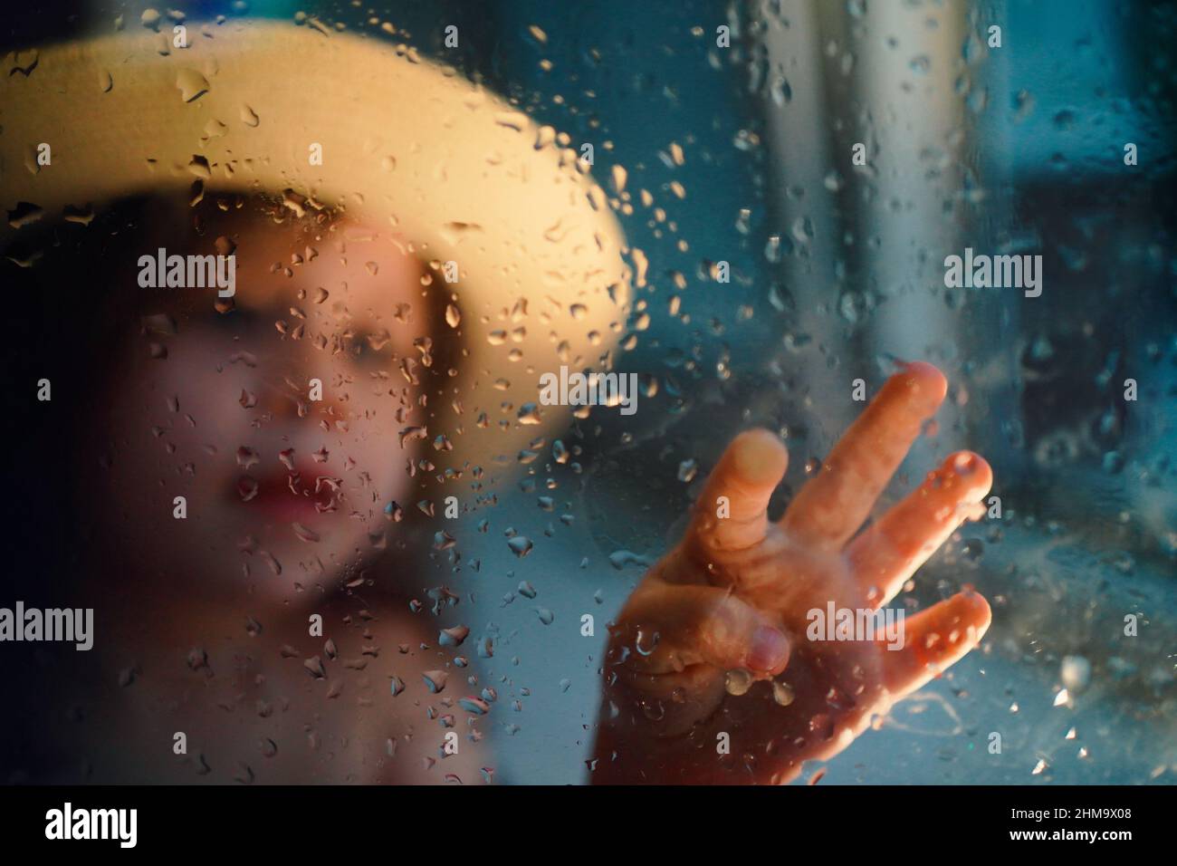 a girl in a straw hat, rain outside the window Stock Photo Alamy
