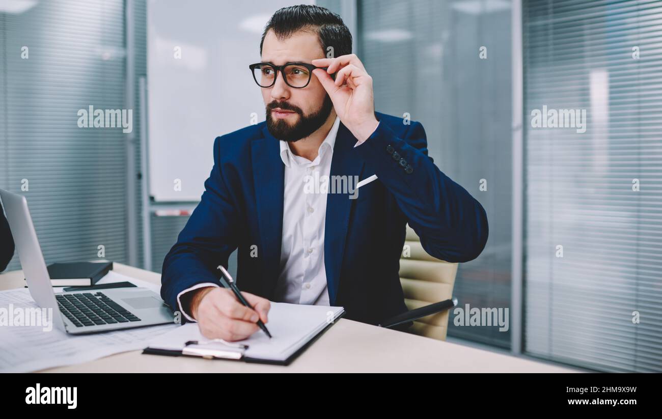 Pensive businessman working in modern workspace Stock Photo
