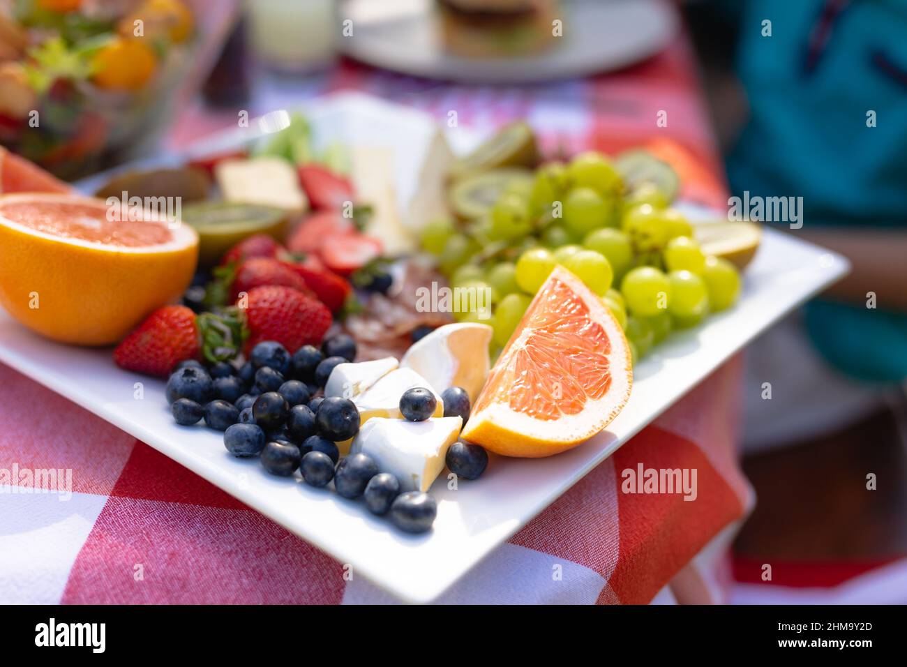 Close-up selective focus of various fruits with cheese slices in tray on table Stock Photo