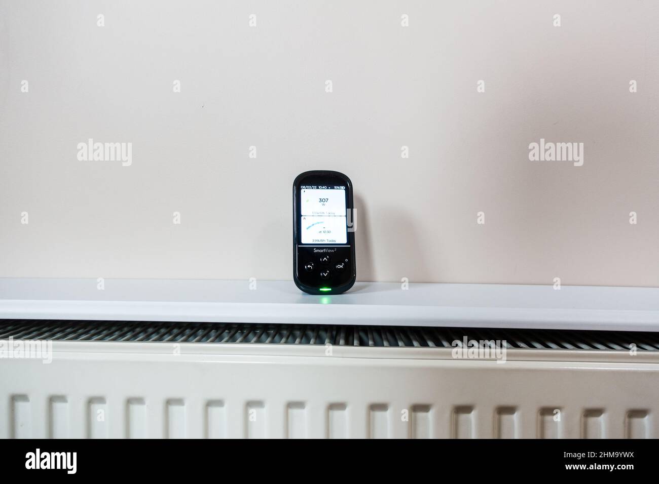 UK electric and gas usage smart energy meter display on a room radiator indicating the cost of rising gas price Stock Photo