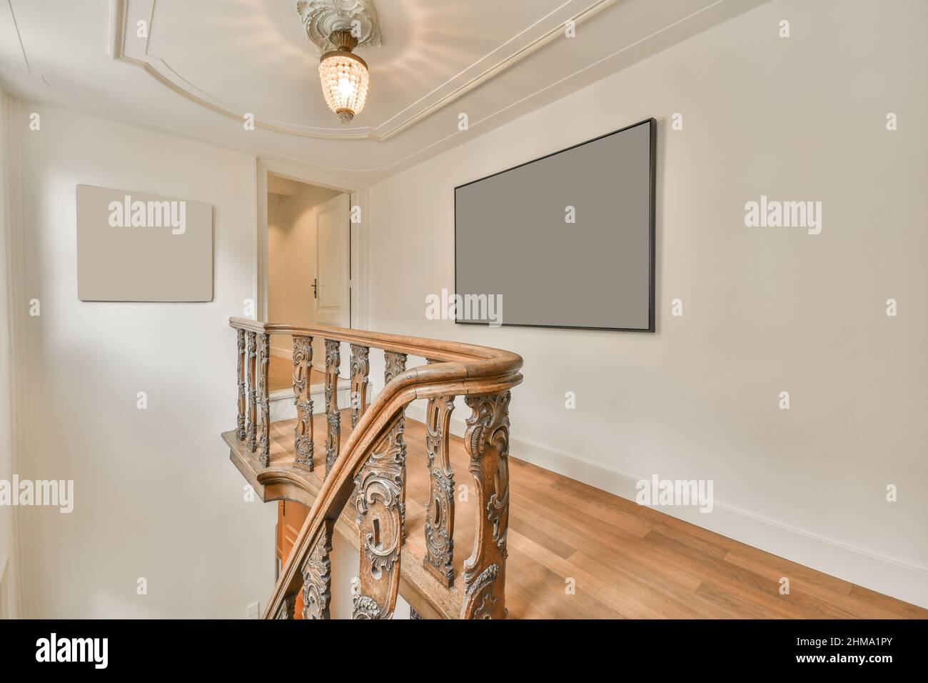 Corridor with wooden stairway with ornamental railing placed against ...