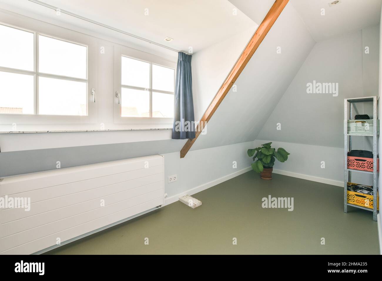 Attic Radiator Light attic with storage containers on shelves placed near potted green ...