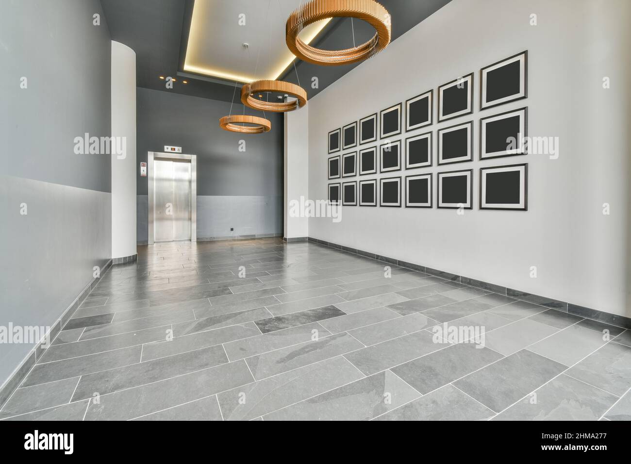 Interior of empty entrance lobby with empty black frames on white wall and  shiny doors of elevator in luxury penthouse stylish apartment Stock Photo -  Alamy