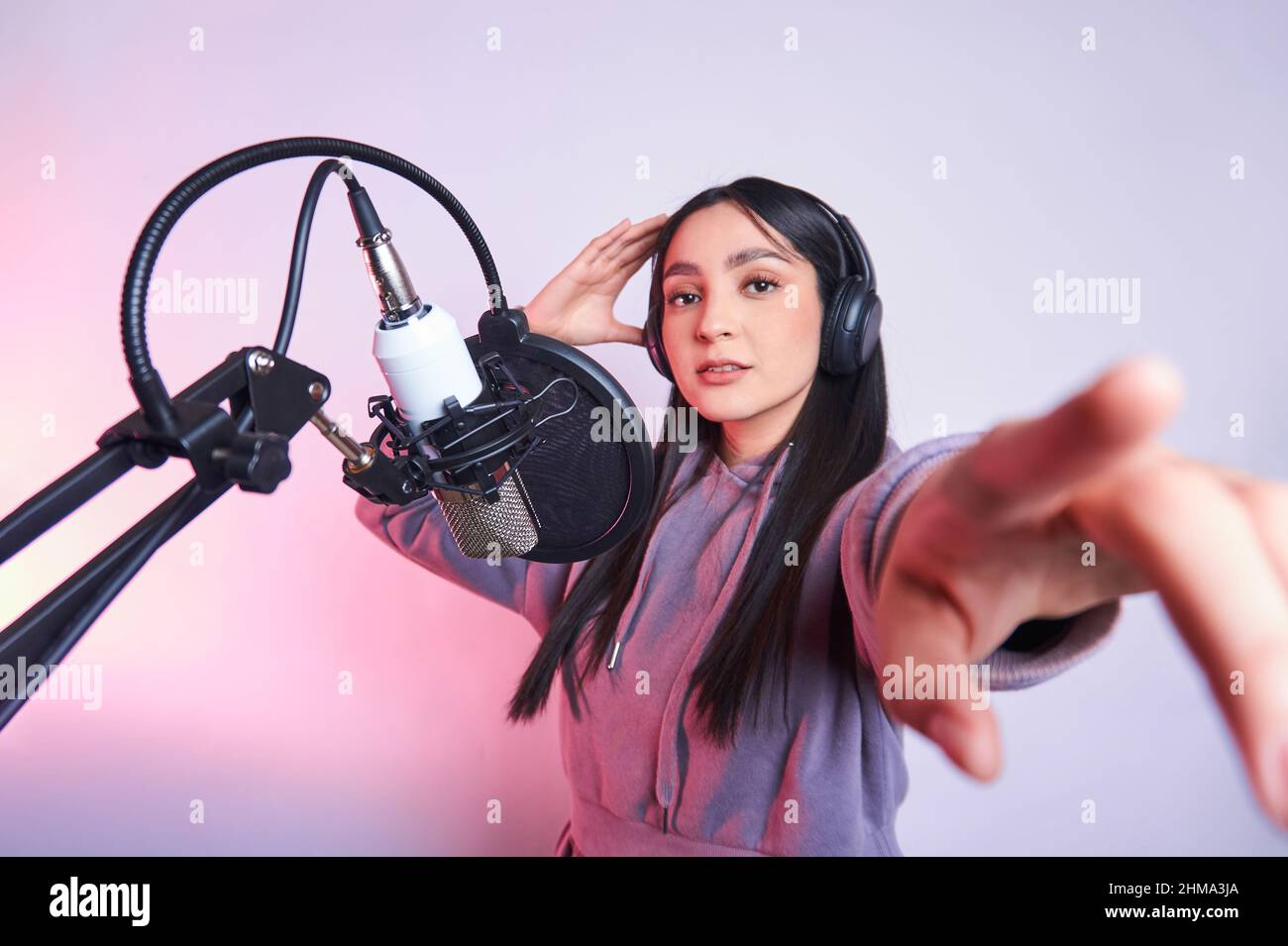 Young talented female casual wear and headphones singing into