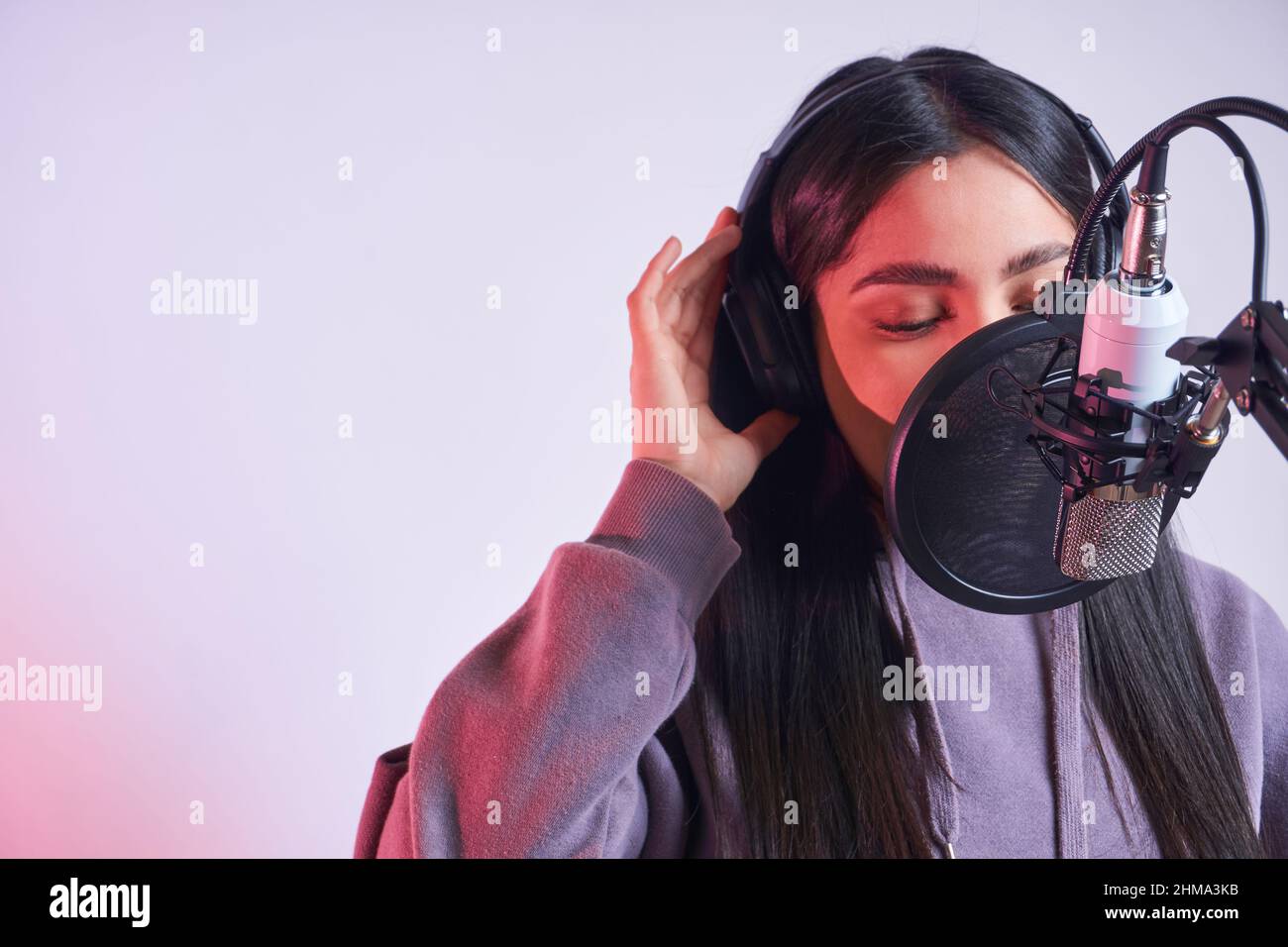 Young talented female casual wear and headphones singing into