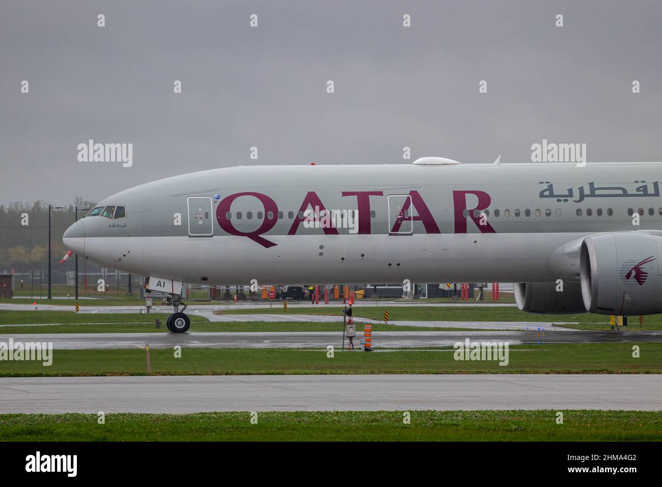 Montreal, Quebec, Canada 10-02-2021: The front half of a Qatar Boeing B777 landing in Montreal, arriving from Doha on a rainy afternoon. Registration Stock Photo