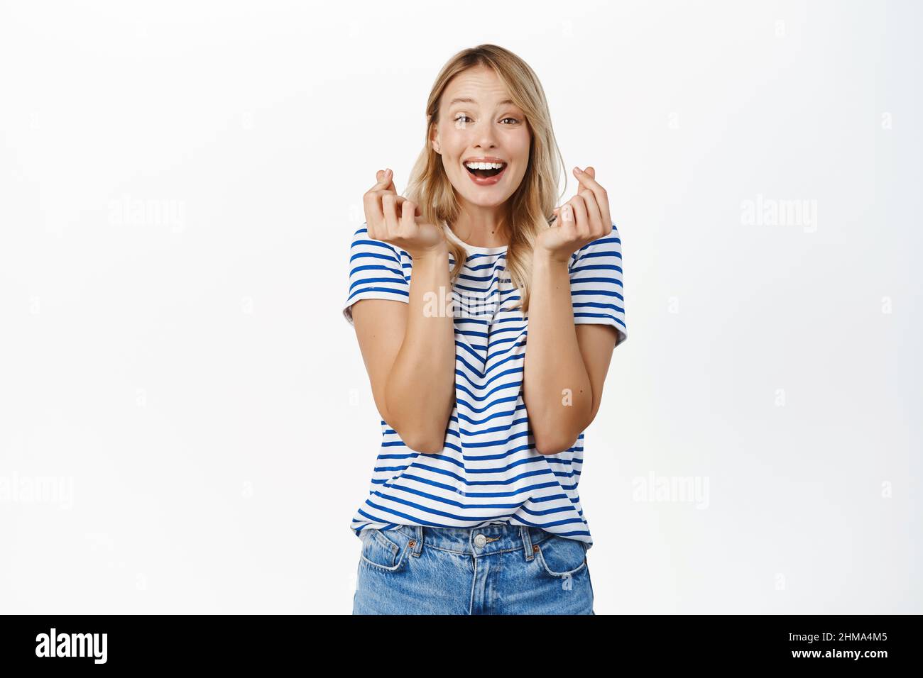 Image of excited smiling beautiful girl, showing finger hearts and ...
