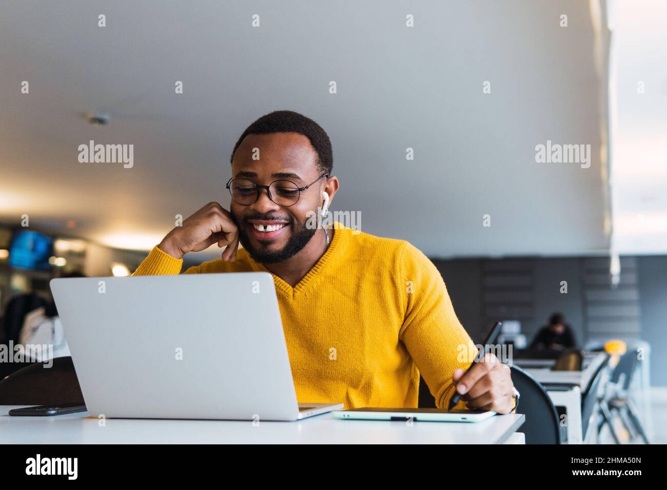 Positive bearded African American male entrepreneur taking notes on