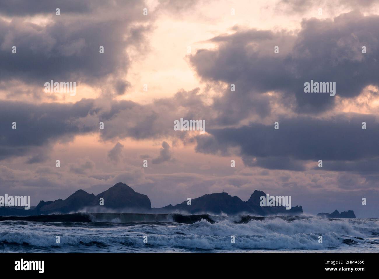 View towards Vestmannaeyjar islands off the south coast of Iceland under dramatic clouds at dusk Stock Photo