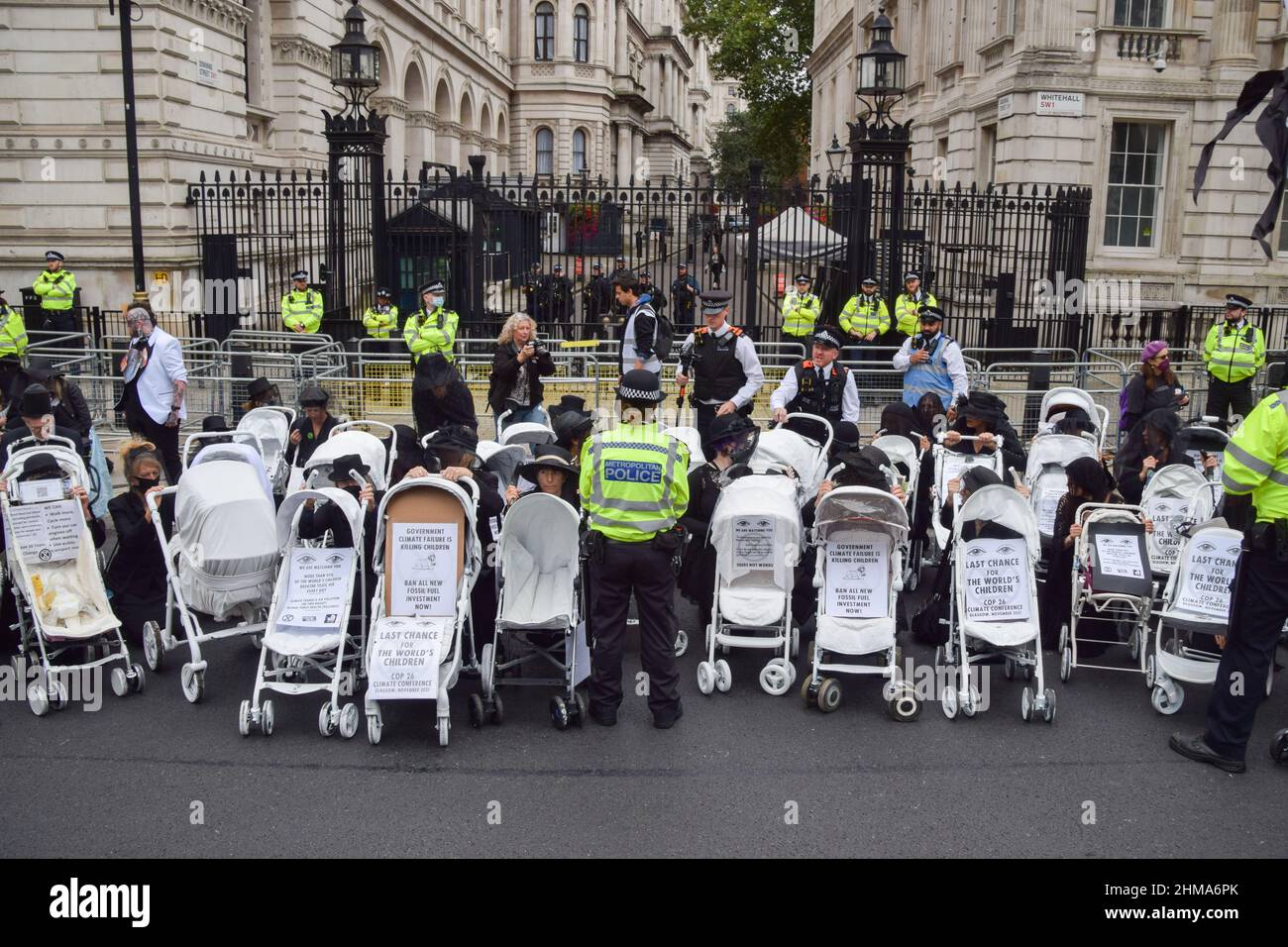 London, United Kingdom. 31st August 2021. Police observe protesters attached to prams outside Downing Street. Extinction Rebellion protesters dressed in black marched with prams in Westminster as part of their two-week Impossible Rebellion campaign. Stock Photo