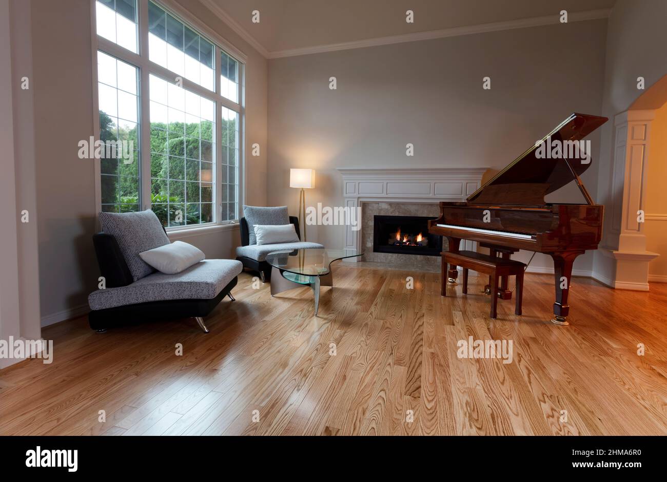 Newly remodeled large living room with glowing fireplace and piano on