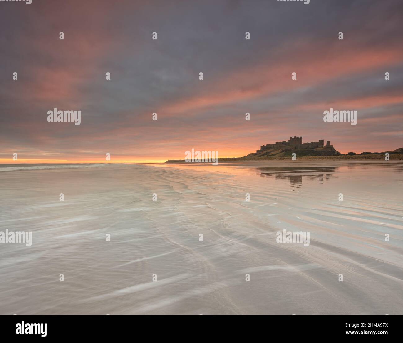 Bamburgh Castle on the Northumberland coastline during sunrise Stock Photo