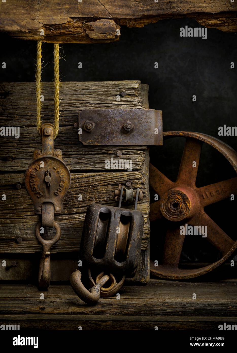 Old pulley, block and tackle, and iron wheel among old barn wood as