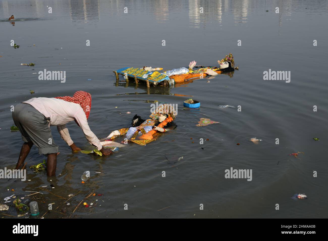 A man floating Hindu goddess Saraswati idol for immersion on the Ganges