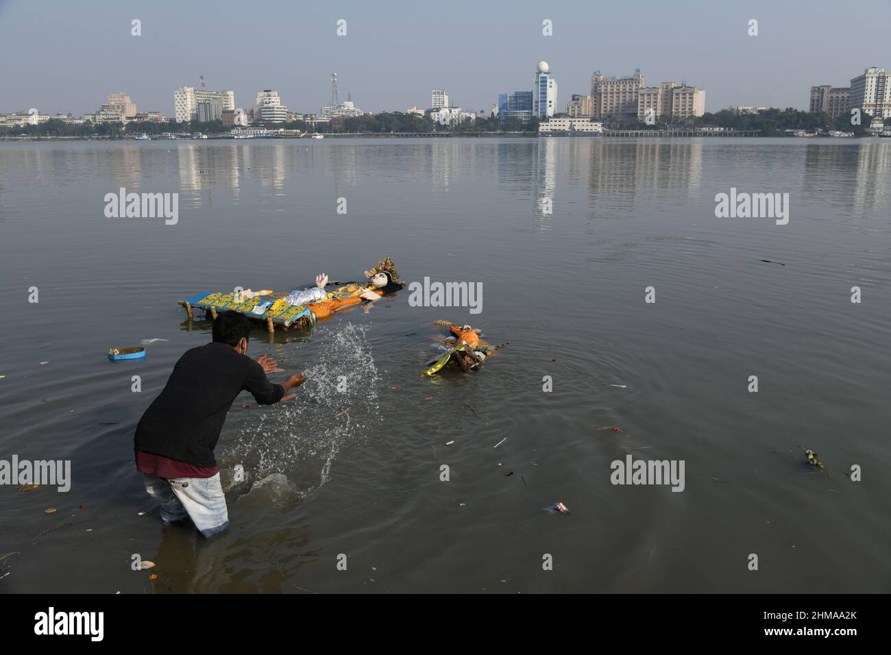A man floating Hindu goddess Saraswati idol for immersion on the Ganges