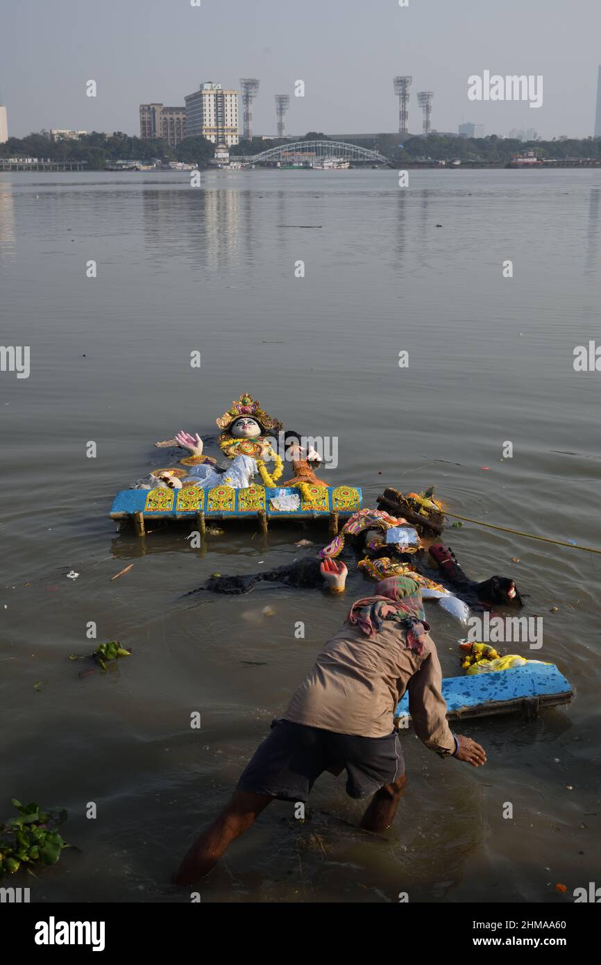 A man floating Hindu goddess Saraswati idol for immersion on the Ganges