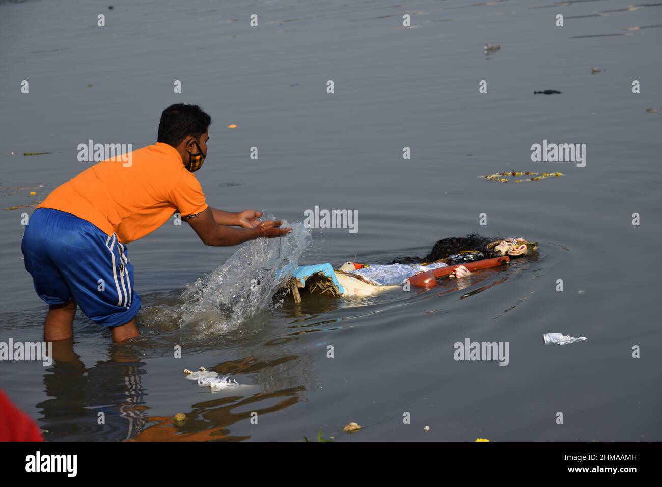 A man floating Hindu goddess Saraswati idol for immersion on the Ganges