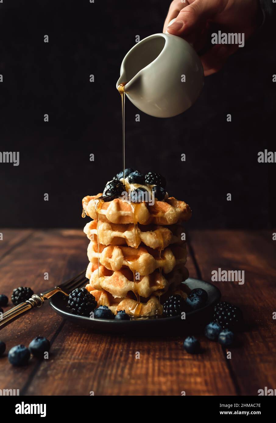 Pouring syrup over waffles berries hi-res stock photography and images ...