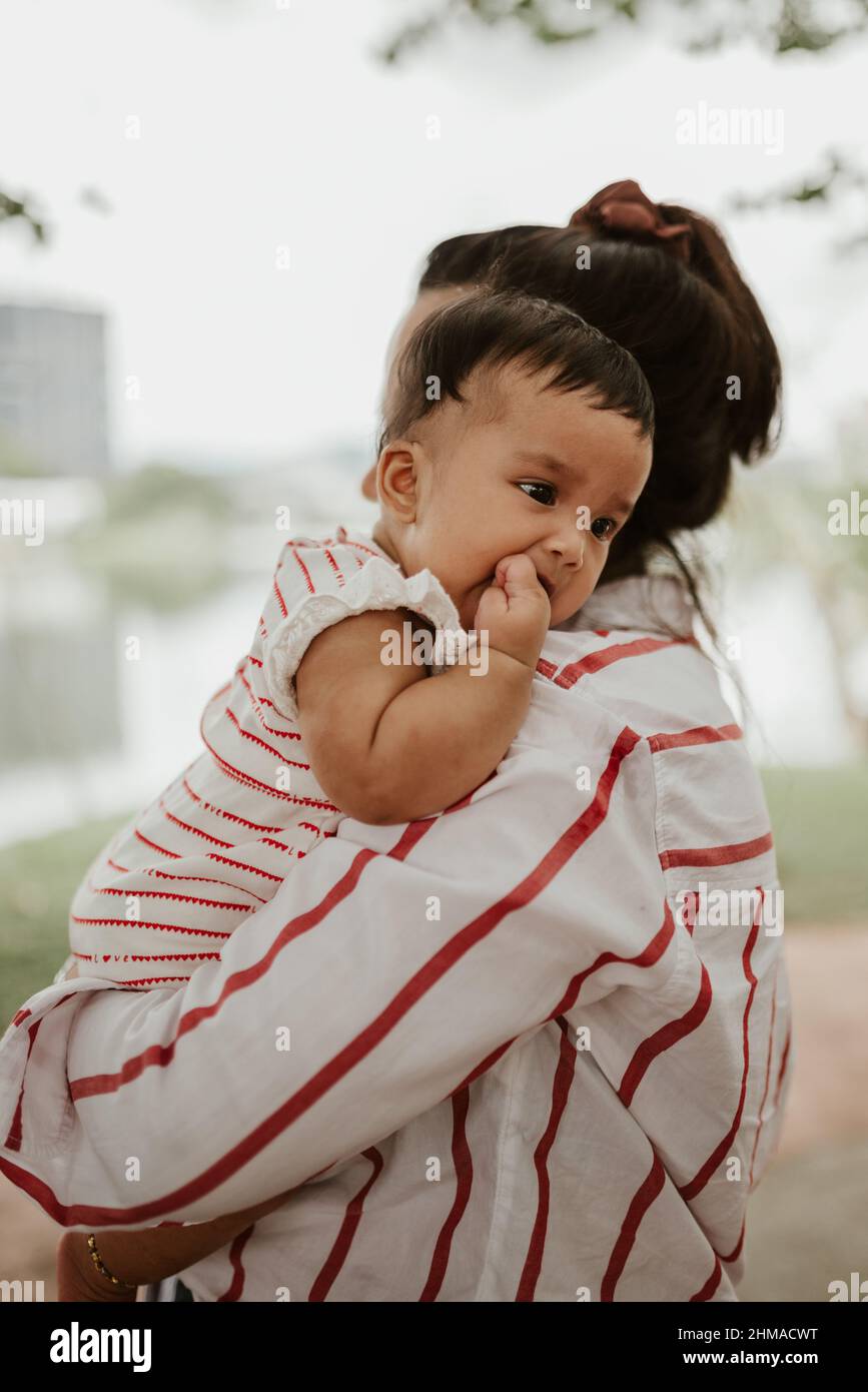 Mother holding baby girl at the park Stock Photo