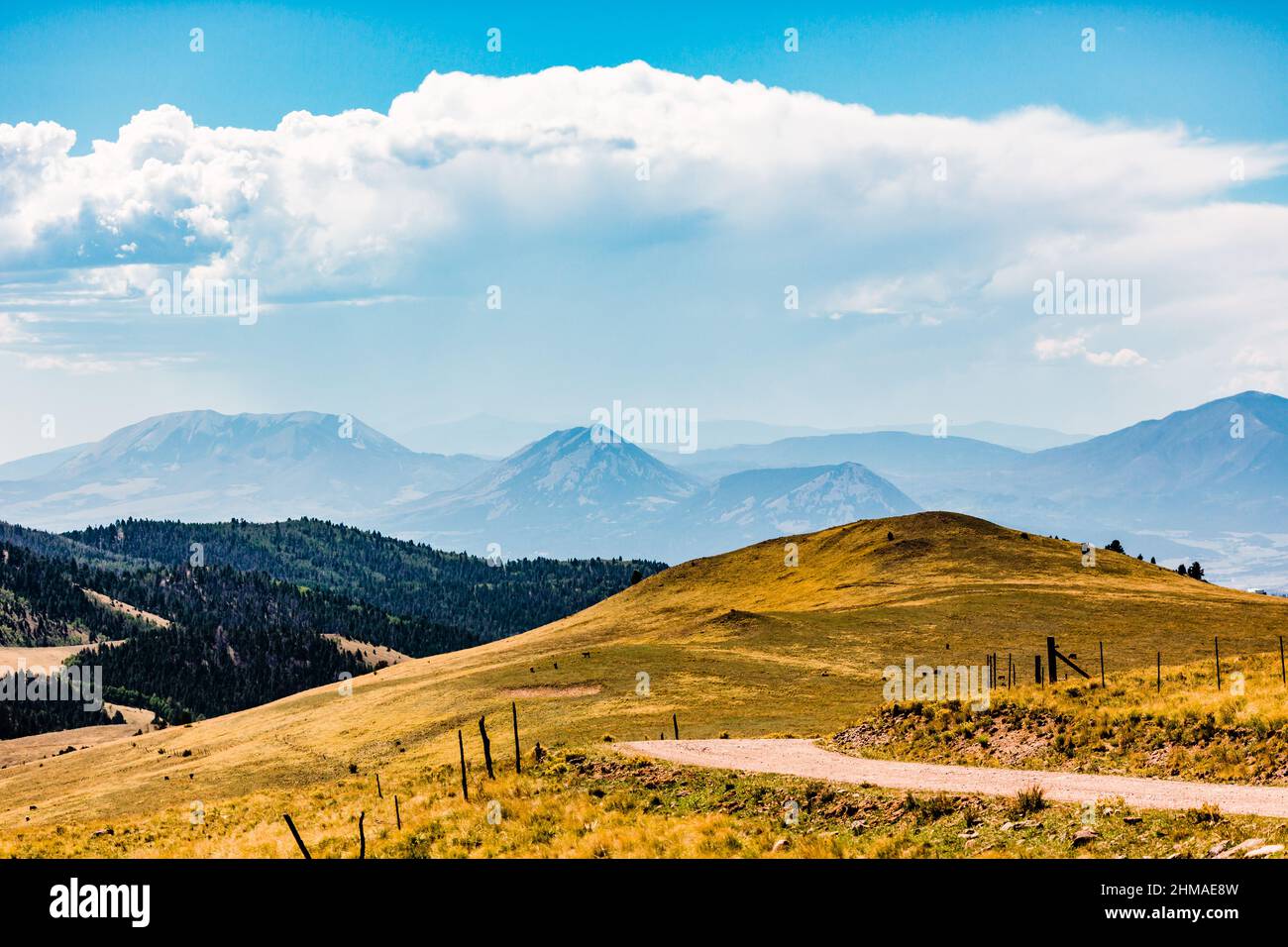 Billowing Clouds Over Colorado Mountains with Dirt Road Stock Photo